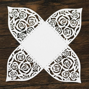 Detail of laser-cut white cardstock wedding gift box with intricate rose patterns
