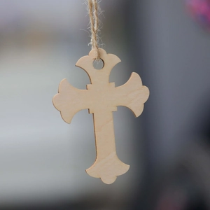 Detail of laser-cut wooden cross ornament with natural twine rope for festive decor