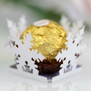 Close-up of white laser-cut snowflake chocolate base for Christmas party favors