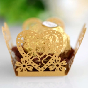 Macro view of golden heart-shaped laser-cut hollow candy wrappers for wedding favors