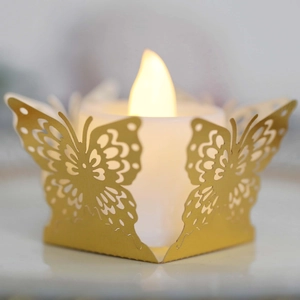 Détail d'un photophore papillon doré découpé au laser avec une bougie LED à lumière chaude