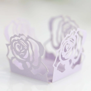 Makroaufnahme von hellvioletten lasergeschnittenen Rosen-Papierförmchen für Hochzeiten