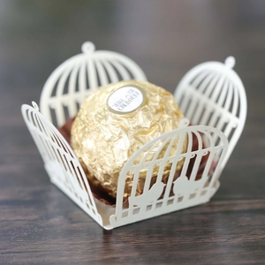 Detailed laser-cut birdcage pattern on ivory paper candy holder for wedding decor