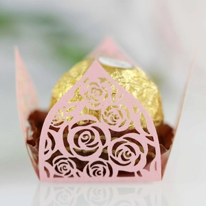 Close-up of laser-cut pink rose paper chocolate wrapper with elegant crown design