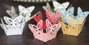 Detailed laser cut butterfly cupcake wrappers in various colors for wedding party decor