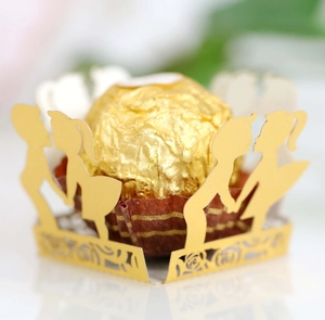 Macro detail of laser-cut gold pearlescent paper chocolate wrapper with kissing couple