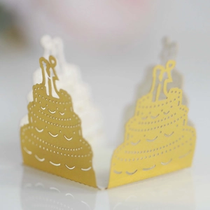 Detail of laser-cut gold cupcake wrapper featuring a bride and groom silhouette topper