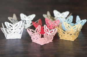 Laser-cut butterfly lace cupcake liners in assorted colors for wedding parties