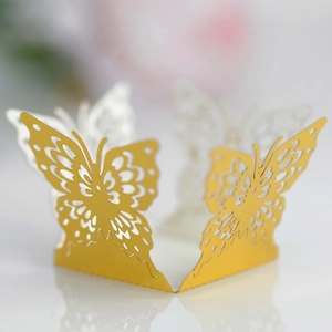 Detailed laser-cut hollow butterfly candle wraps in gold and white for wedding decor