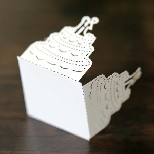 Detailed laser-cut paper lampshade featuring a romantic wedding cake design and couple silhouette