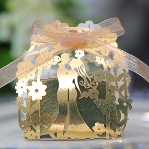 Detailed laser cut gold wedding favor box with silhouette design and ribbon