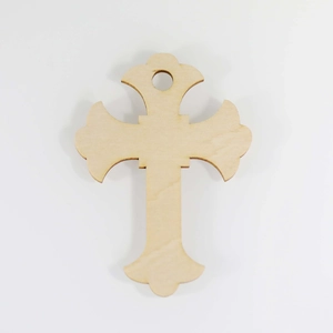 Close-up of decorative hollow wooden cross pendant with precise laser cutouts and hanging hole