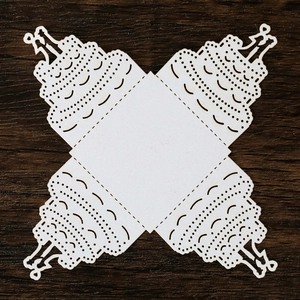 Laser-cut white wedding cake paper lantern with intricate hollow patterns and silhouettes