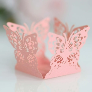 Close-up of laser-cut pink butterfly hollow paper wrapper for wedding cupcake decoration
