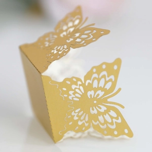 Detailed laser-cut gold hollow butterfly favor box with intricate pearlescent paper texture