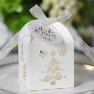 Close-up of white laser-cut Christmas gift box with silver ribbon and thank you tag