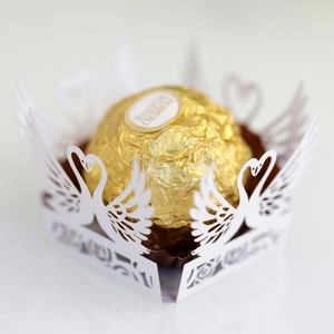 Detail of laser-cut white swan paper wrapper for chocolates and wedding candy favors