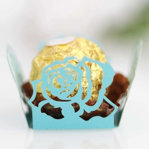 Makroaufnahme hellblaue Pralinenmanschette mit lasergeschnittenem Rosenmuster