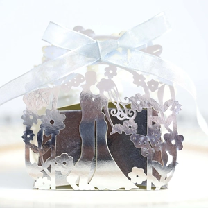 Close-up of silver laser-cut wedding favor box with bride and groom silhouette