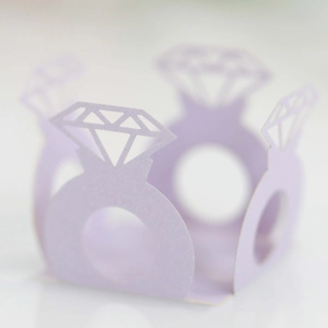 Macro shot of lavender pearlescent paper cupcake wrapper with cutout diamond ring design
