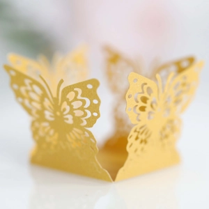 Macro shot of gold butterfly laser-cut hollow decoration for chocolate and cupcakes