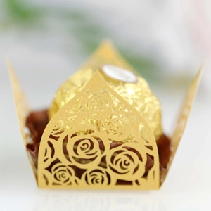 Macro shot of laser-cut gold rose pattern hollow candy wrapper for weddings