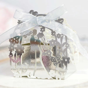 Close-up of laser-cut silver wedding favor box with bride silhouette and ribbon bow