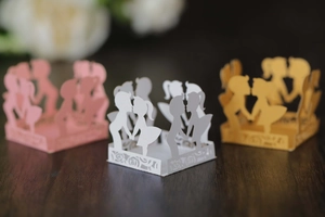 Detailed laser-cut hollow candy boxes for weddings in white, pink, and gold pearl paper