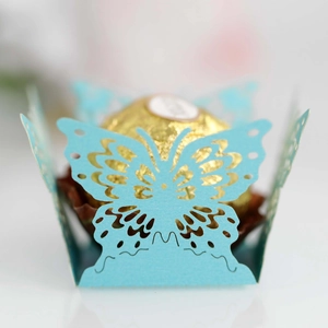 Macro view of blue laser-cut butterfly candy box with golden chocolate detail
