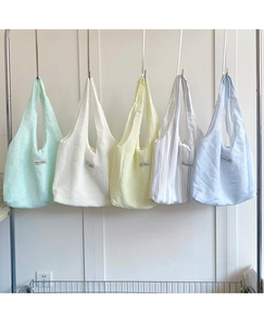 Detailed close-up of macaron color canvas tote bags in mint, ivory and striped patterns