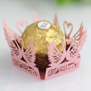 Close-up of pink laser-cut hollow swan and heart favor box for chocolate decoration