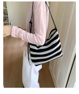 Détail du sac cabas en maille rayée noir et blanc avec bandoulière en cuir réglable
