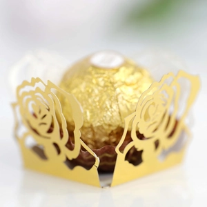 Makroaufnahme von goldener lasergeschnittener Rosen-Pralinenhülle für Hochzeitsdeko