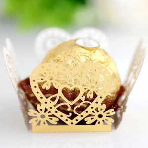 Close-up of golden laser-cut heart candy wrapper with intricate floral hollow patterns