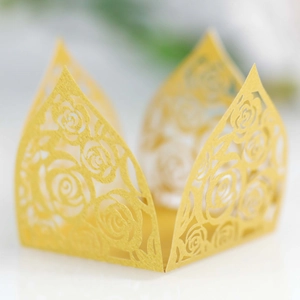 Macro shot of gold hollow laser-cut paper candy box with rose floral patterns