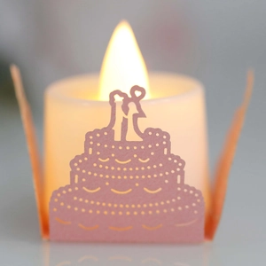 Pink laser cut paper lantern sleeve in 3-tier wedding cake design with warm LED candle light