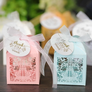 Close-up of laser-cut Eiffel Tower favor boxes with ribbons and thank you tags