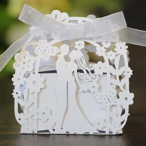 Laser cut white wedding favor box featuring bride and groom silhouette with silk ribbon