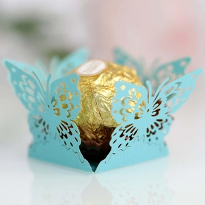 Detail of light blue laser-cut butterfly candy box with a chocolate inside for weddings