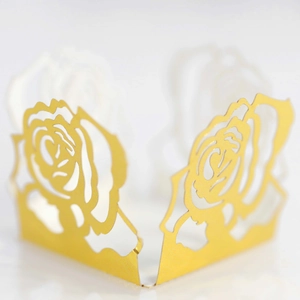Makroaufnahme von lasergeschnittener goldener Rosen-Papierhülle für Hochzeitsbonbons