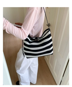 Vue détaillée du sac cabas tissé à rayures noires et blanches avec bouton en bois et maille