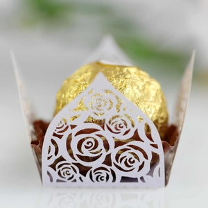 Macro shot of laser-cut white paper lace candy box with intricate rose flower pattern details
