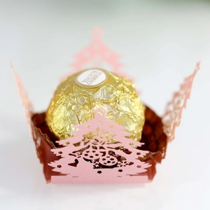 Detail of pink laser-cut Christmas tree chocolate wrapper with hollow design