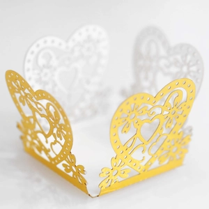 Detailed laser-cut heart pattern on gold wedding cupcake wrapper for elegant parties