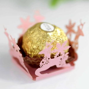 Vista macro di involucri rosa per cioccolatini tagliati al laser con renne e fiocchi di neve