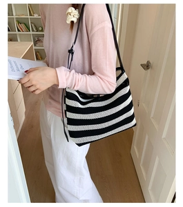 Gros plan d'un sac cabas tissé à rayures noires et blanches avec texture en maille souple