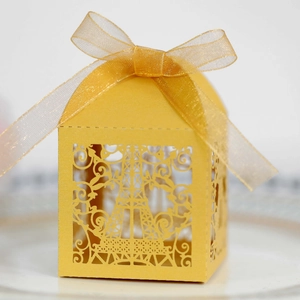 Detail showing gold laser-cut candy box with Eiffel Tower design and organza ribbon