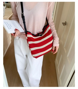 Détail du sac fourre-tout en tricot rayé rouge et blanc avec bandoulière en cuir noir