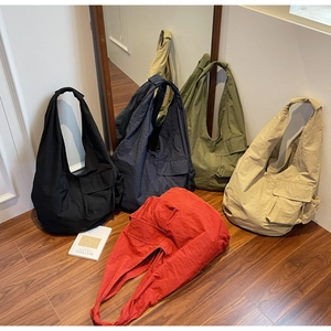 Detail view of large nylon tote bags in five colors with functional cargo pockets