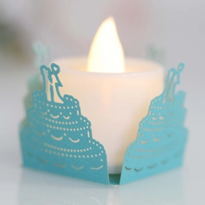 Detailed laser-cut paper candle wrap with three-tier wedding cake silhouette and LED candle